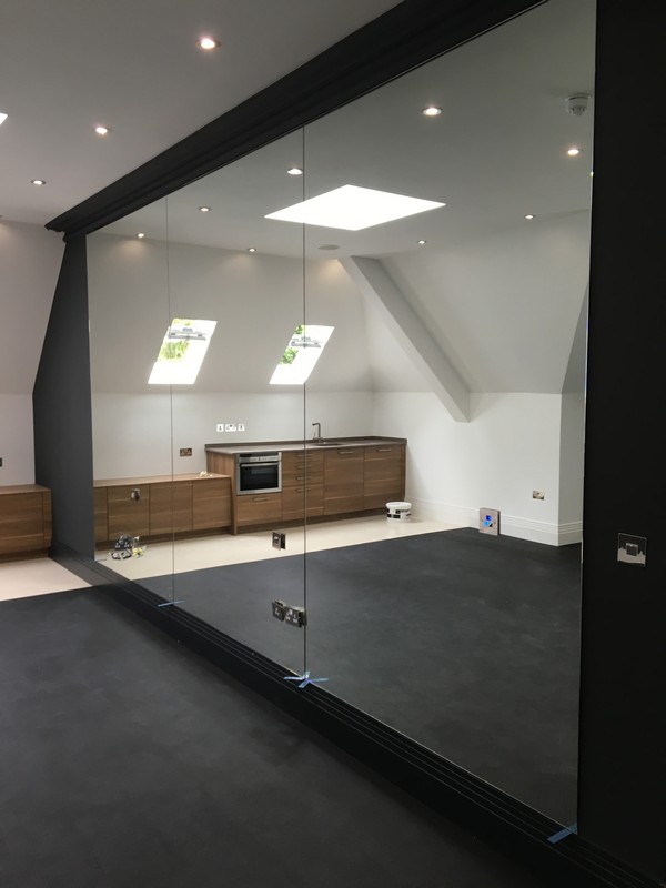 Frameless glass partition in loft conversion by West Kensington glaziers