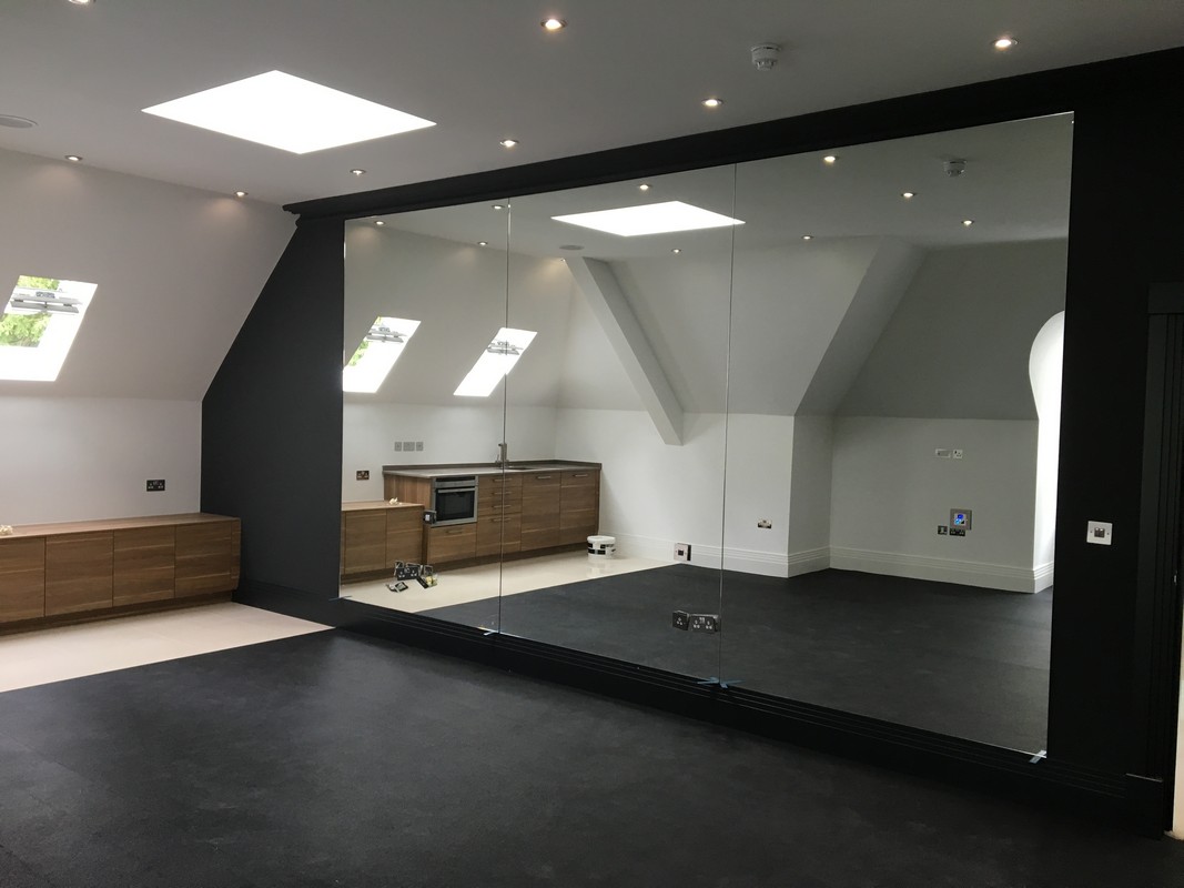 Frameless glass wall dividing loft conversion in West Kensington