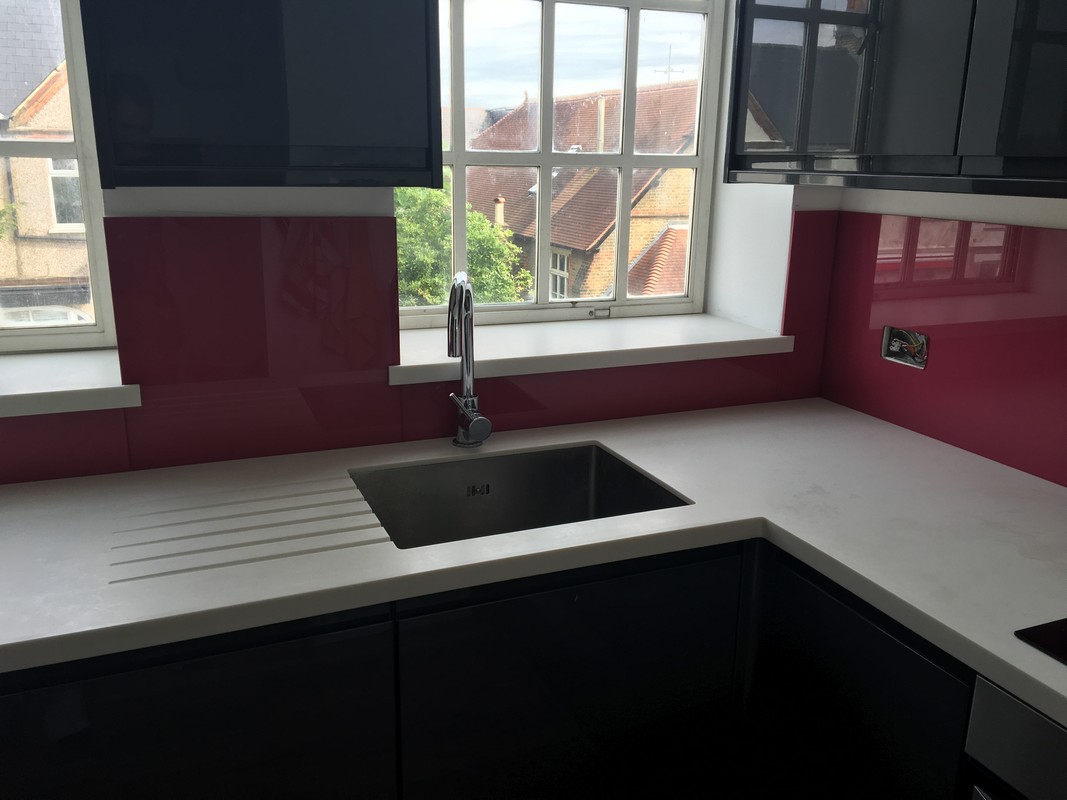 Deep plum coloured glass splashback in modern West Kensington kitchen